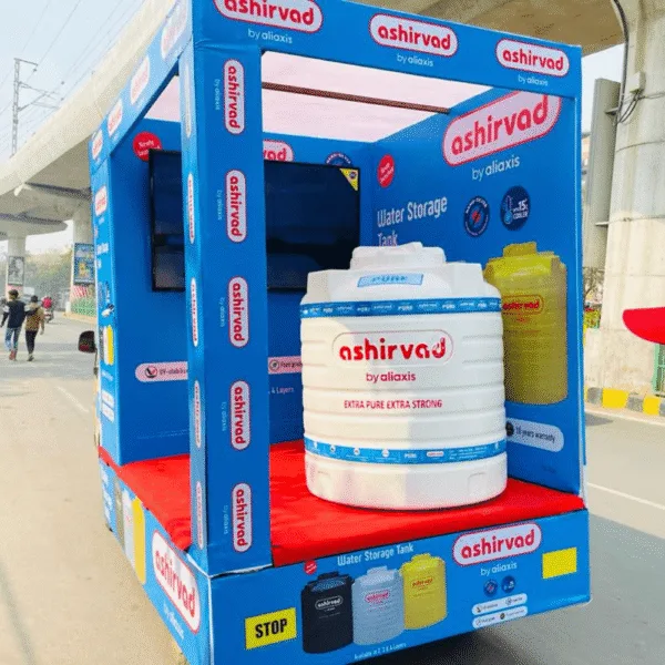 Outdoor advertising agency roadshow display for Ashirvad water storage tanks with 3D model and mobile van branding.